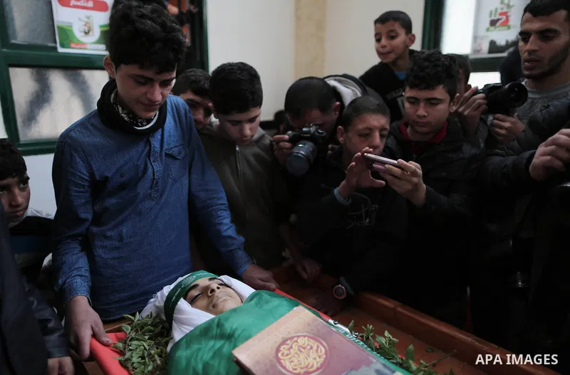 A file photo taken on January 14, 2019, shows Ali al-Ashqar, 17, (L) who was killed by Israeli troops on September 06, 2019, mourns over the body of his friend Abdul Raouf Salha, who was died of his wounds which he susta...