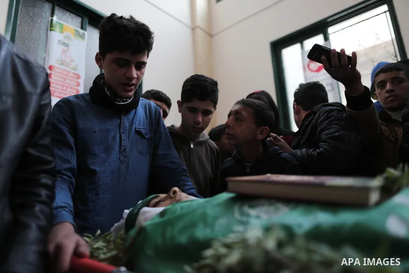 A file photo taken on January 14, 2019, shows Ali al-Ashqar, 17, (L) who was killed by Israeli troops on September 06, 2019, mourns over the body of his friend Abdul Raouf Salha, who was died of his wounds which he susta...