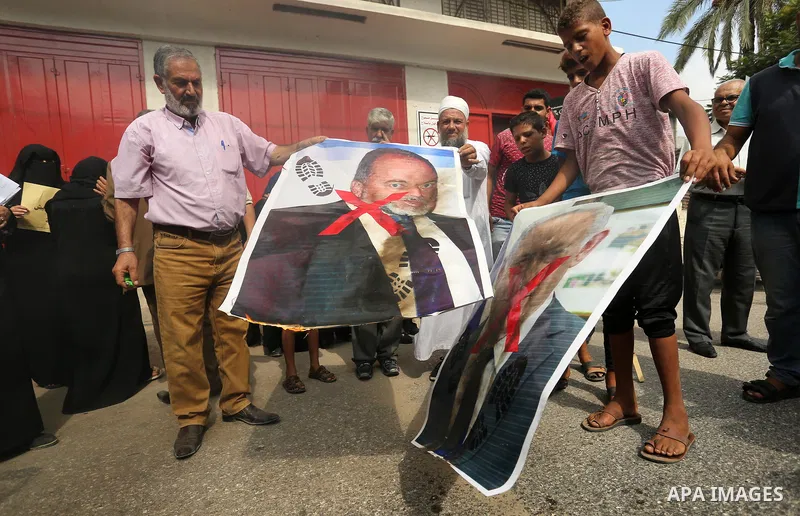Palestinian supporters of the Democratic Front for the Liberation of Palestine (DFLP) burn pictures depicting Israeli Prime Minister Benjamin Netanyahu and Avigdor Lieberman, head of Yisrael Beitenu party, during a prote...