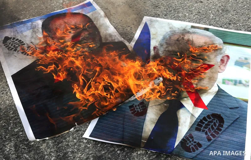 Palestinian supporters of the Democratic Front for the Liberation of Palestine (DFLP) burn pictures depicting Israeli Prime Minister Benjamin Netanyahu and Avigdor Lieberman, head of Yisrael Beitenu party, during a prote...