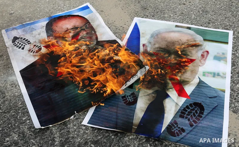 Palestinian supporters of the Democratic Front for the Liberation of Palestine (DFLP) burn pictures depicting Israeli Prime Minister Benjamin Netanyahu and Avigdor Lieberman, head of Yisrael Beitenu party, during a prote...