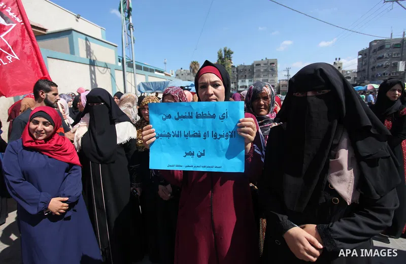 Palestinian supporters of the Democratic Front for the Liberation of Palestine (DFLP), hold placards during a rally in support of the headquarters United Nations Relief and Works Agency (UNRWA), outside its headquarters...