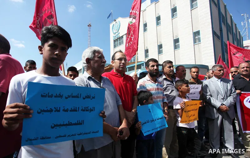 Palestinian supporters of the Democratic Front for the Liberation of Palestine (DFLP), hold placards during a rally in support of the headquarters United Nations Relief and Works Agency (UNRWA), outside its headquarters...