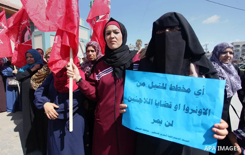 Palestinian supporters of the Democratic Front for the Liberation of Palestine (DFLP), hold placards during a rally in support of the headquarters United Nations Relief and Works Agency (UNRWA), outside its headquarters...