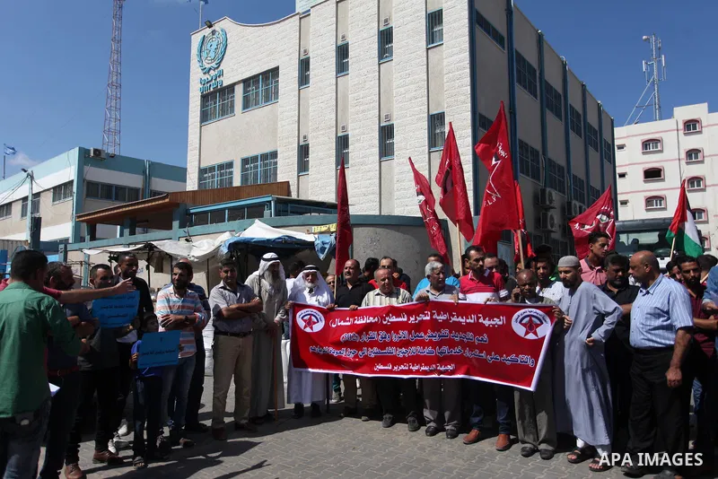 Palestinian supporters of the Democratic Front for the Liberation of Palestine (DFLP), hold placards during a rally in support of the headquarters United Nations Relief and Works Agency (UNRWA), outside its headquarters...