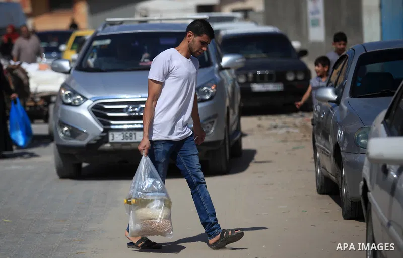 A Palestinian man carries a bag of flour to distribute to families, at an aid distribution centre of the United Nations Relief and Works Agency (UNRWA) in Jabalia in the northern Gaza Strip, on SEP. 21, 2019. Photo by Ma...