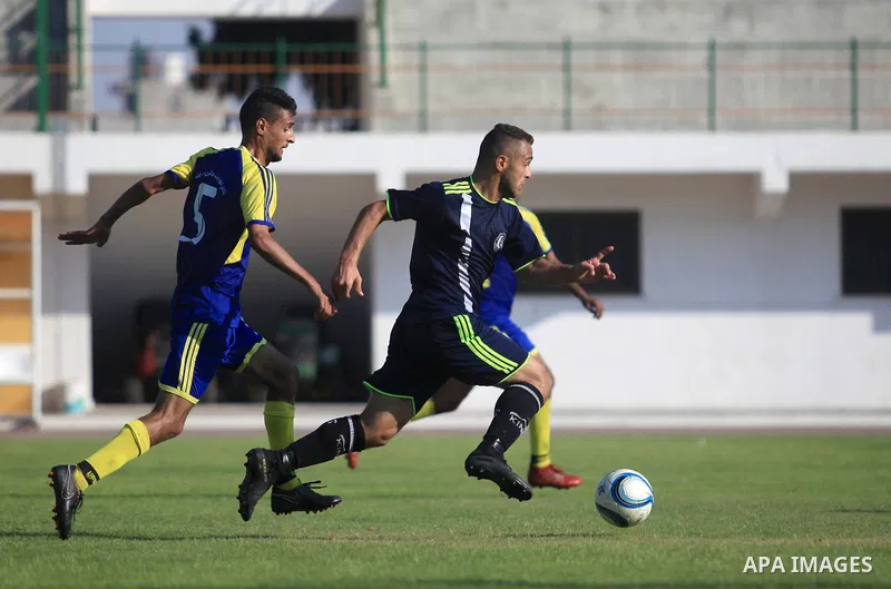 Palestinian football players of Etihad Beit Hanoun (blue) and Alhilal (Dark blue) compete during match premier League in Alyarmuk stadium, in Gaza City on September 22, 2019. Photo by Mahmoud Ajjour