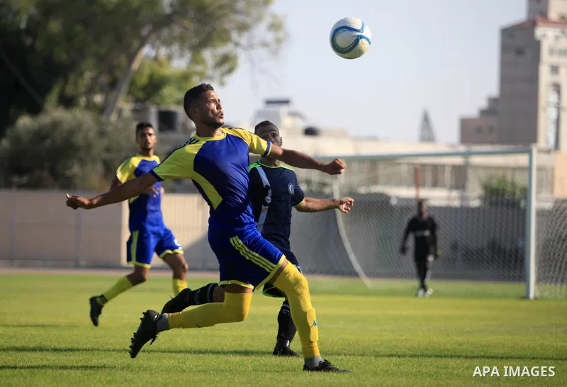 Palestinian football players of Etihad Beit Hanoun (blue) and Alhilal (Dark blue) compete during match premier League in Alyarmuk stadium, in Gaza City on September 22, 2019. Photo by Mahmoud Ajjour