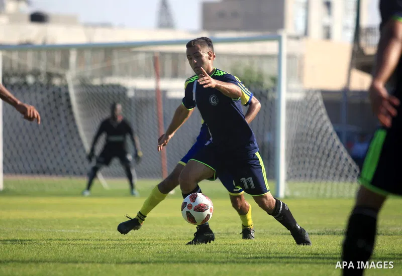 Palestinian football players of Etihad Beit Hanoun (blue) and Alhilal (Dark blue) compete during match premier League in Alyarmuk stadium, in Gaza City on September 22, 2019. Photo by Mahmoud Ajjour