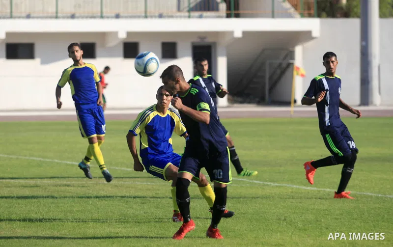Palestinian football players of Etihad Beit Hanoun (blue) and Alhilal (Dark blue) compete during match premier League in Alyarmuk stadium, in Gaza City on September 22, 2019. Photo by Mahmoud Ajjour