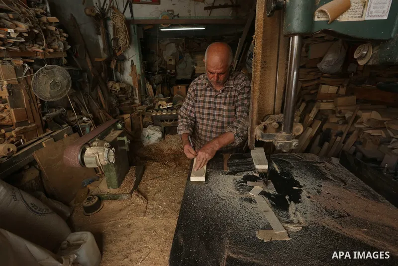 A Palestinian man Waleed Khudair, 69, works on wood to makes the Sabot "wooden shoes" at his workshop in the West Bank city of Nablus, on September 25, 2019. Photo by Shadi Jarar'ah