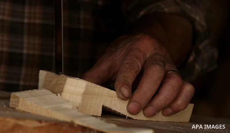 A Palestinian man Waleed Khudair, 69, works on wood to makes the Sabot "wooden shoes" at his workshop in the West Bank city of Nablus, on September 25, 2019. Photo by Shadi Jarar'ah