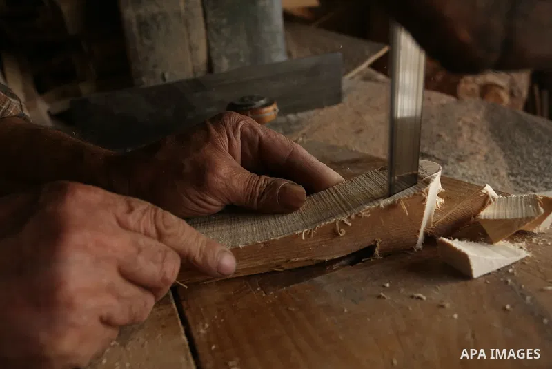 A Palestinian man Waleed Khudair, 69, works on wood to makes the Sabot "wooden shoes" at his workshop in the West Bank city of Nablus, on September 25, 2019. Photo by Shadi Jarar'ah