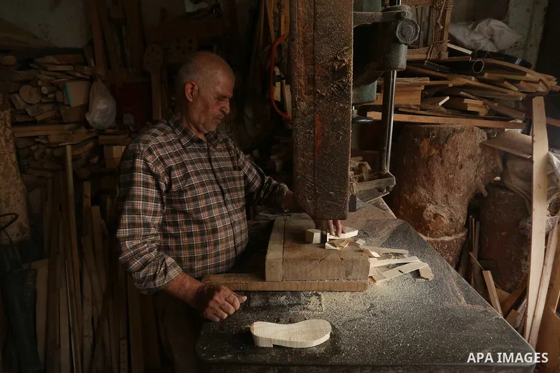 A Palestinian man Waleed Khudair, 69, works on wood to makes the Sabot "wooden shoes" at his workshop in the West Bank city of Nablus, on September 25, 2019. Photo by Shadi Jarar'ah