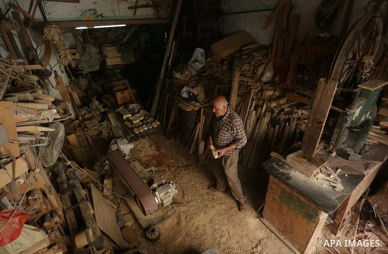 A Palestinian man Waleed Khudair, 69, works on wood to makes the Sabot "wooden shoes" at his workshop in the West Bank city of Nablus, on September 25, 2019. Photo by Shadi Jarar'ah