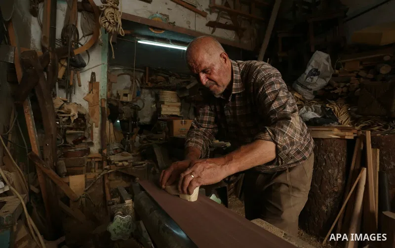 A Palestinian man Waleed Khudair, 69, works on wood to makes the Sabot "wooden shoes" at his workshop in the West Bank city of Nablus, on September 25, 2019. Photo by Shadi Jarar'ah