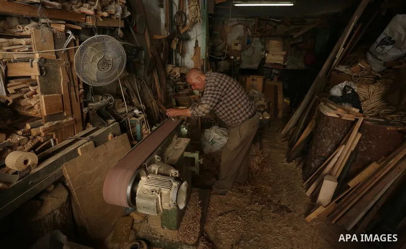 A Palestinian man Waleed Khudair, 69, works on wood to makes the Sabot "wooden shoes" at his workshop in the West Bank city of Nablus, on September 25, 2019. Photo by Shadi Jarar'ah