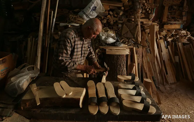 A Palestinian man Waleed Khudair, 69, works on wood to makes the Sabot "wooden shoes" at his workshop in the West Bank city of Nablus, on September 25, 2019. Photo by Shadi Jarar'ah