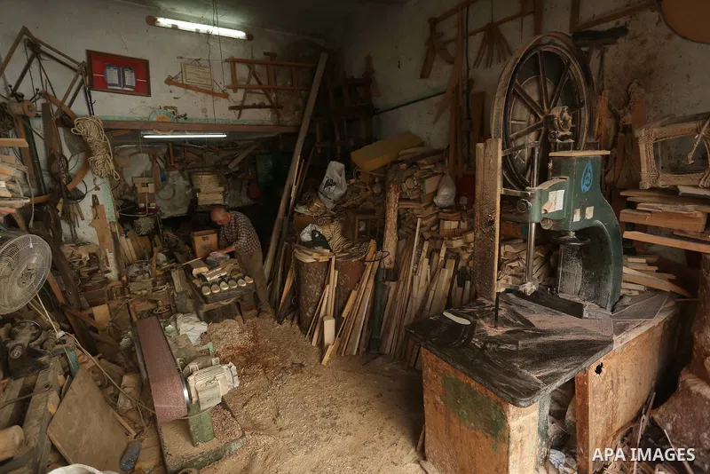 A Palestinian man Waleed Khudair, 69, works on wood to makes the Sabot "wooden shoes" at his workshop in the West Bank city of Nablus, on September 25, 2019. Photo by Shadi Jarar'ah