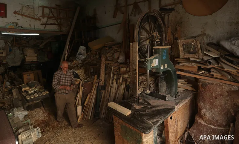 A Palestinian man Waleed Khudair, 69, works on wood to makes the Sabot "wooden shoes" at his workshop in the West Bank city of Nablus, on September 25, 2019. Photo by Shadi Jarar'ah
