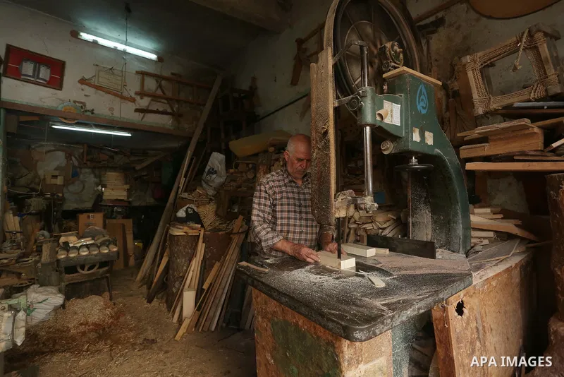 A Palestinian man Waleed Khudair, 69, works on wood to makes the Sabot "wooden shoes" at his workshop in the West Bank city of Nablus, on September 25, 2019. Photo by Shadi Jarar'ah