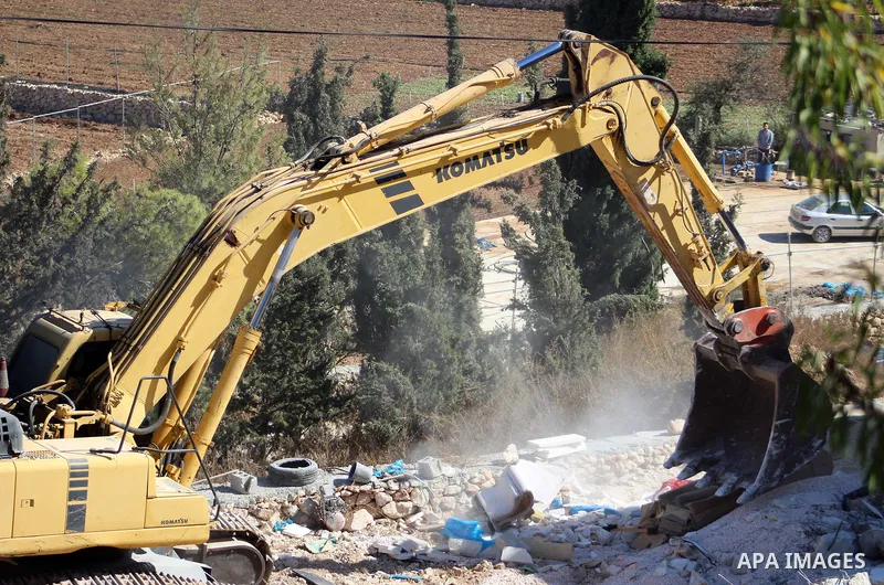 An Israeli bulldozer demolishes a Palestinian building which does not have the Israeli needed permits on the outskirts of Dura village near the West Bank city of Hebron on September 25, 2019. Israeli bulldozers demolishe...