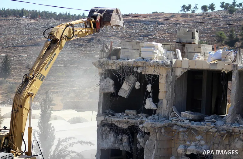 An Israeli bulldozer demolishes a Palestinian building which does not have the Israeli needed permits on the outskirts of Dura village near the West Bank city of Hebron on September 25, 2019. Israeli bulldozers demolishe...