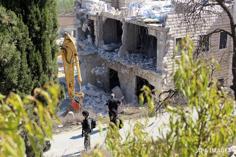 An Israeli bulldozer demolishes a Palestinian building which does not have the Israeli needed permits on the outskirts of Dura village near the West Bank city of Hebron on September 25, 2019. Israeli bulldozers demolishe...