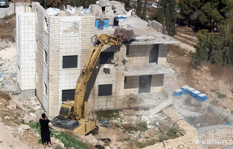 An Israeli bulldozer demolishes a Palestinian building which does not have the Israeli needed permits on the outskirts of Dura village near the West Bank city of Hebron on September 25, 2019. Israeli bulldozers demolishe...