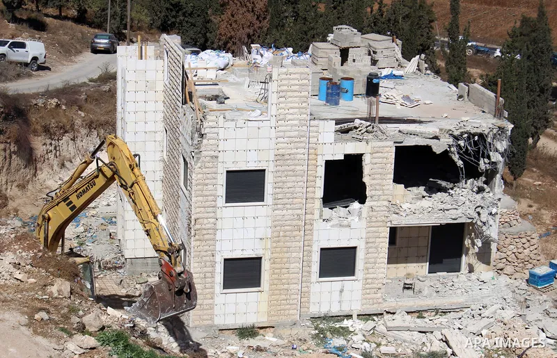 An Israeli bulldozer demolishes a Palestinian building which does not have the Israeli needed permits on the outskirts of Dura village near the West Bank city of Hebron on September 25, 2019. Israeli bulldozers demolishe...