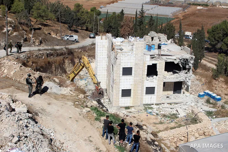 An Israeli bulldozer demolishes a Palestinian building which does not have the Israeli needed permits on the outskirts of Dura village near the West Bank city of Hebron on September 25, 2019. Israeli bulldozers demolishe...