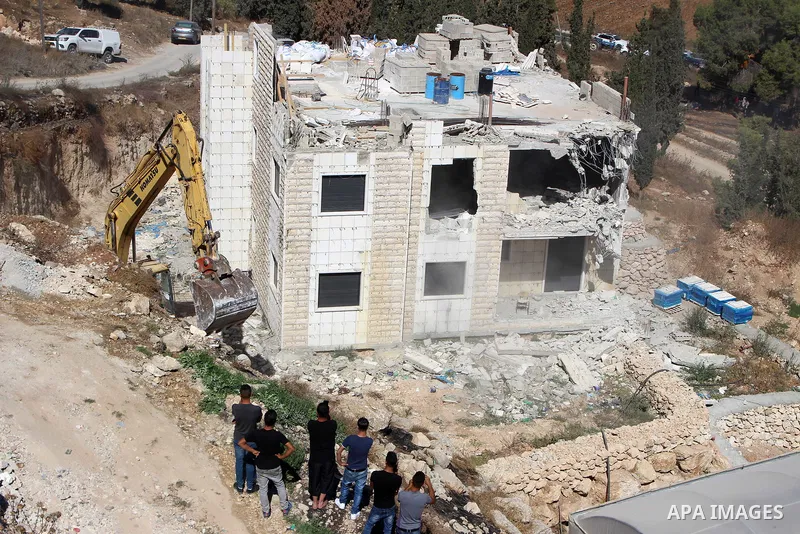 An Israeli bulldozer demolishes a Palestinian building which does not have the Israeli needed permits on the outskirts of Dura village near the West Bank city of Hebron on September 25, 2019. Israeli bulldozers demolishe...