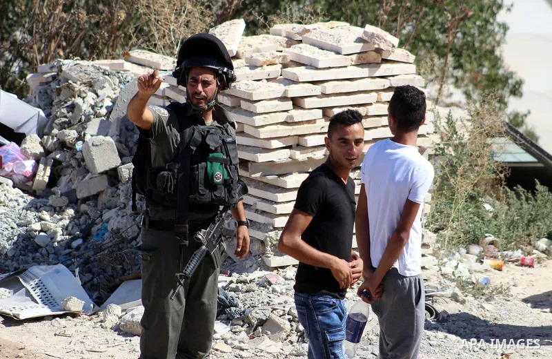 Israeli border police guard as Israeli bulldozer demolishes a Palestinian building which does not have the Israeli needed permits on the outskirts of Dura village near the West Bank city of Hebron on September 25, 2019....
