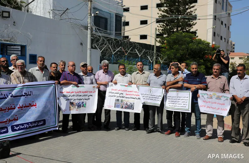 Palestinians, hold placards during a rally in support of the headquarters United Nations Relief and Works Agency (UNRWA), in front of the headquarter United Nation "UNSCO", in Gaza city on September 26, 2019. Photo by As...