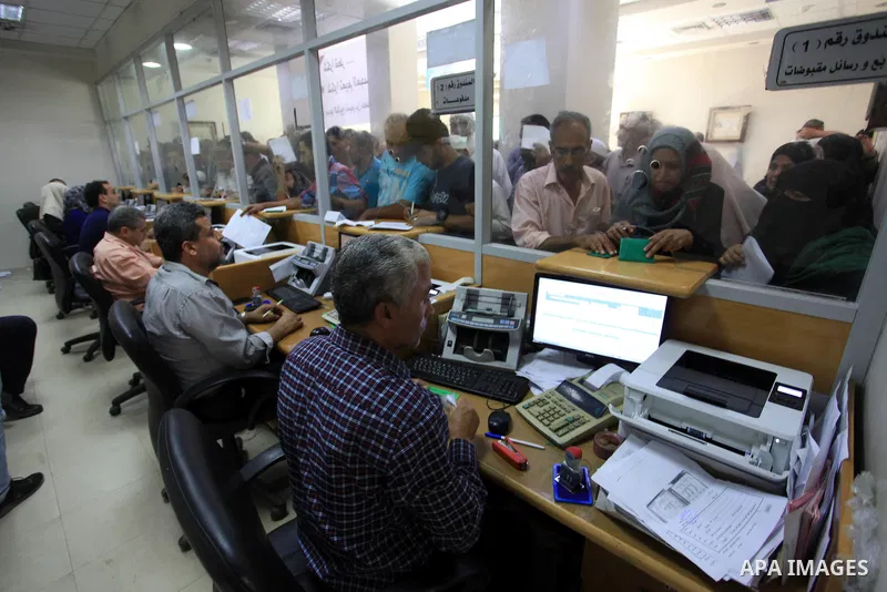 Palestinians wait to receive their financial aid outside the Post Office, in Gaza city, on September 26, 2019. The Qatar grant on Thursday began disbursing $ 100 to Poor Families. Photo by Mahmoud Ajjour