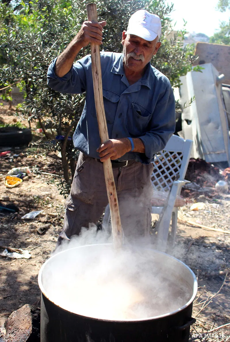 Palestinians prepare a traditional sweets "Malban or Turkish delight" from grape, the West Bank village of Halhul, near Hebron, on September 29, 2019. Hebron is very famous in grape production as it contains many fields...