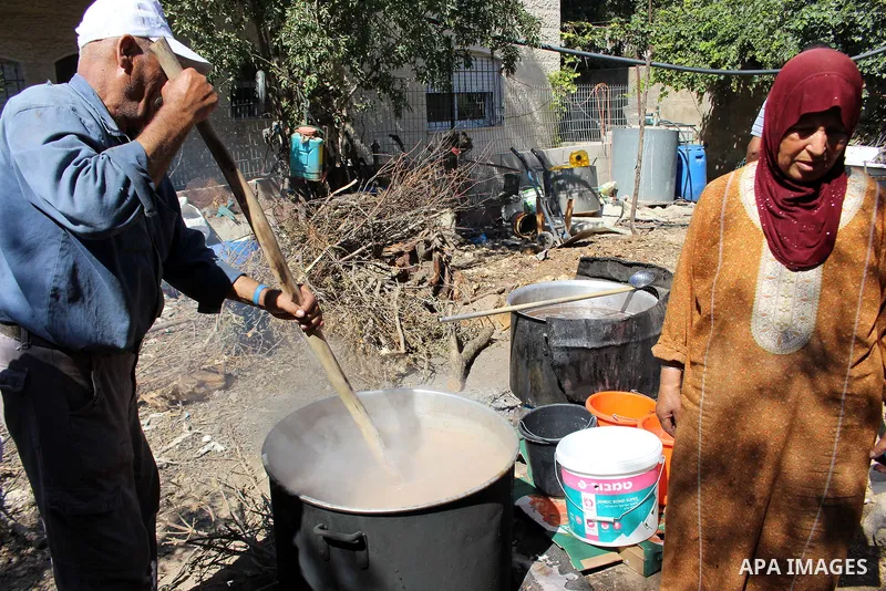 Palestinians prepare a traditional sweets "Malban or Turkish delight" from grape, the West Bank village of Halhul, near Hebron, on September 29, 2019. Hebron is very famous in grape production as it contains many fields...