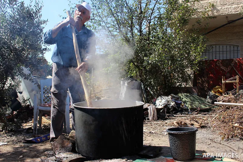 Palestinians prepare a traditional sweets "Malban or Turkish delight" from grape, the West Bank village of Halhul, near Hebron, on September 29, 2019. Hebron is very famous in grape production as it contains many fields...