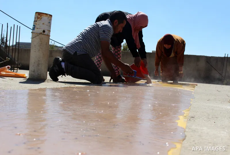 Palestinians prepare a traditional sweets "Malban or Turkish delight" from grape, the West Bank village of Halhul, near Hebron, on September 29, 2019. Hebron is very famous in grape production as it contains many fields...