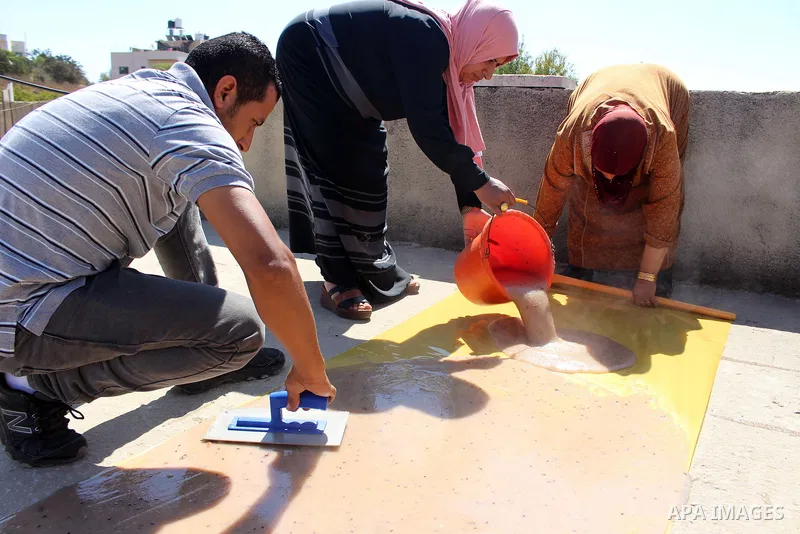 Palestinians prepare a traditional sweets "Malban or Turkish delight" from grape, the West Bank village of Halhul, near Hebron, on September 29, 2019. Hebron is very famous in grape production as it contains many fields...