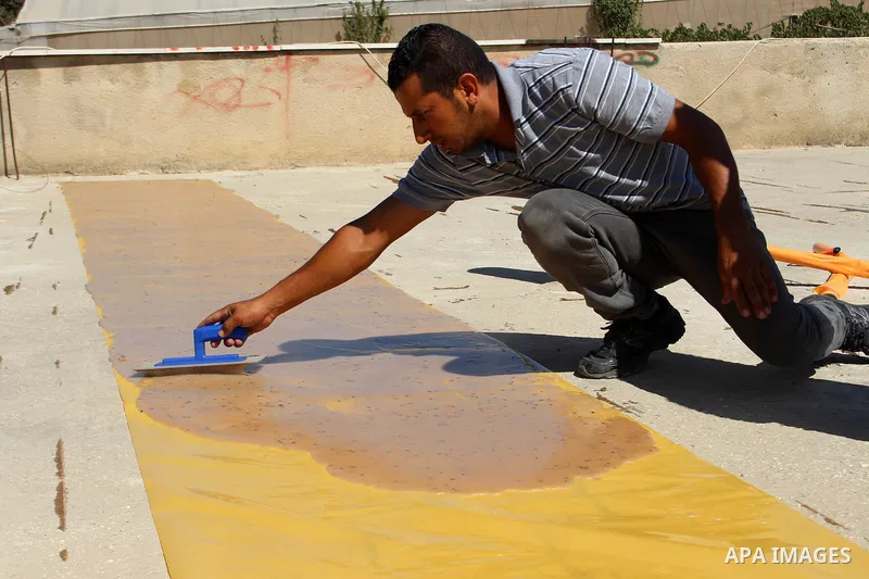 Palestinians prepare a traditional sweets "Malban or Turkish delight" from grape, the West Bank village of Halhul, near Hebron, on September 29, 2019. Hebron is very famous in grape production as it contains many fields...