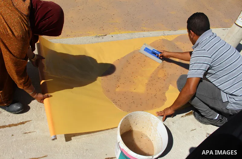 Palestinians prepare a traditional sweets "Malban or Turkish delight" from grape, the West Bank village of Halhul, near Hebron, on September 29, 2019. Hebron is very famous in grape production as it contains many fields...