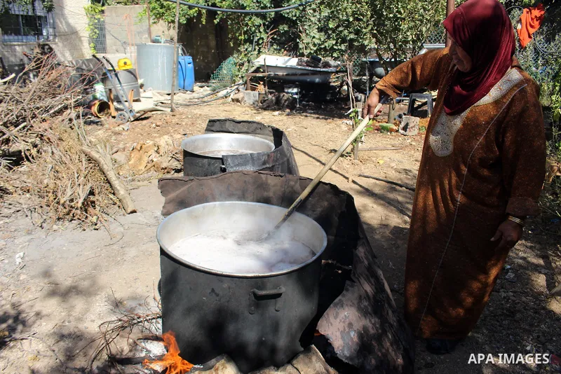 Palestinians prepare a traditional sweets "Malban or Turkish delight" from grape, the West Bank village of Halhul, near Hebron, on September 29, 2019. Hebron is very famous in grape production as it contains many fields...