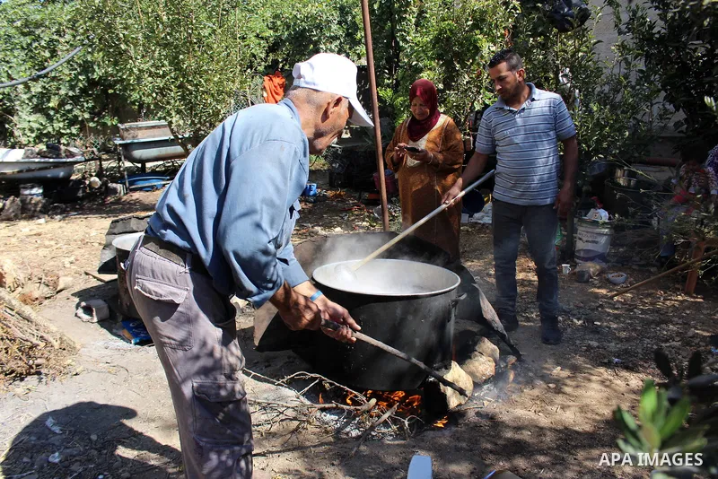 Palestinians prepare a traditional sweets "Malban or Turkish delight" from grape, the West Bank village of Halhul, near Hebron, on September 29, 2019. Hebron is very famous in grape production as it contains many fields...