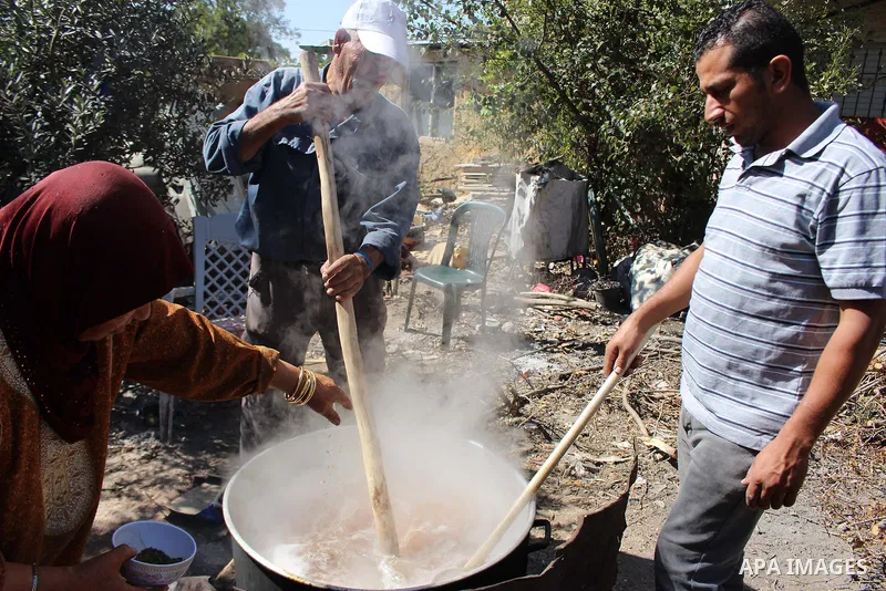Palestinians prepare a traditional sweets "Malban or Turkish delight" from grape, the West Bank village of Halhul, near Hebron, on September 29, 2019. Hebron is very famous in grape production as it contains many fields...