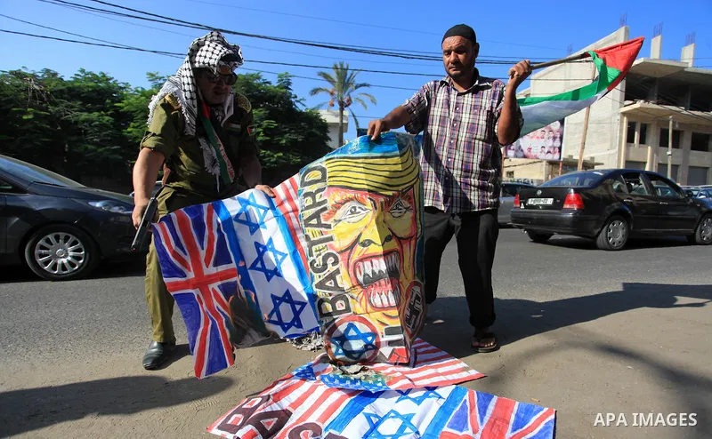 Palestinians burn an Israeli, British and U.S. flags during a protest to show solidarity with Palestinian prisoners held in Israeli jails, in front of Red cross office in Gaza city on September 30, 2019. Photo by Mahmoud...