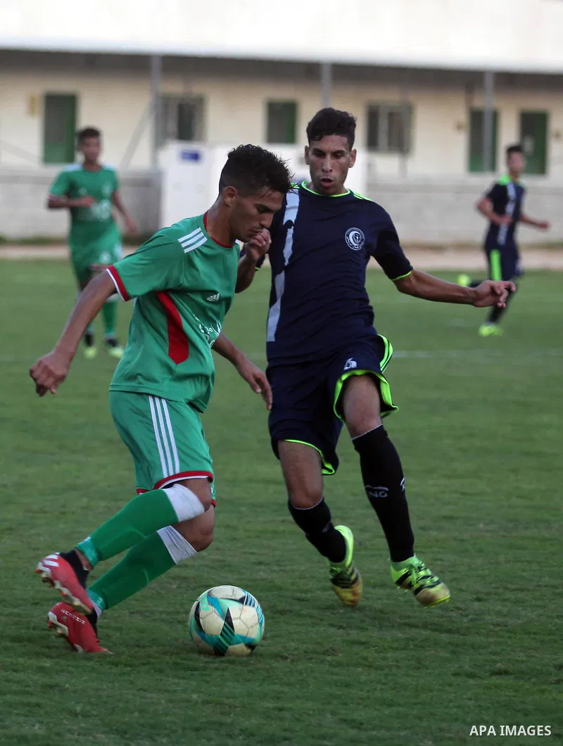 Palestinian football players of Etihad All-Shijaiyah (Green) and Al-Hilal (Dark blue) compete during match premier League in Alyarmuk stadium, in Gaza City, on October 7, 2019. Photo by Mahmoud Ajjour