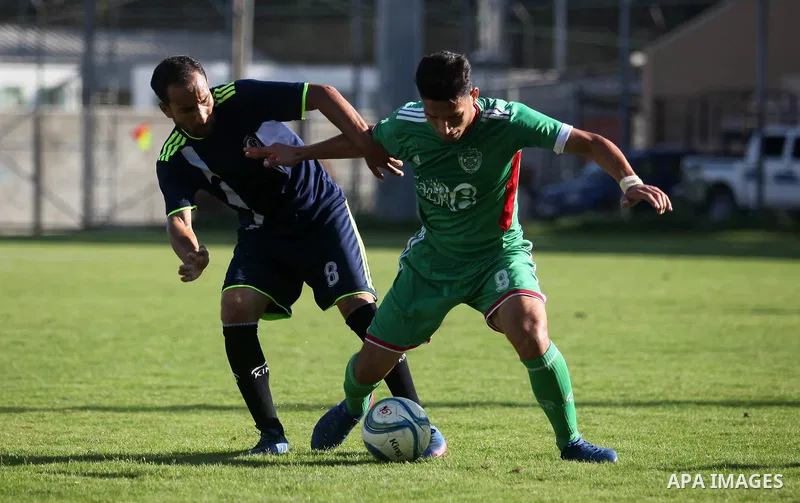 Palestinian football players of Etihad All-Shijaiyah (Green) and Al-Hilal (Dark blue) compete during match premier League in Alyarmuk stadium, in Gaza City, on October 7, 2019. Photo by Mahmoud Ajjour