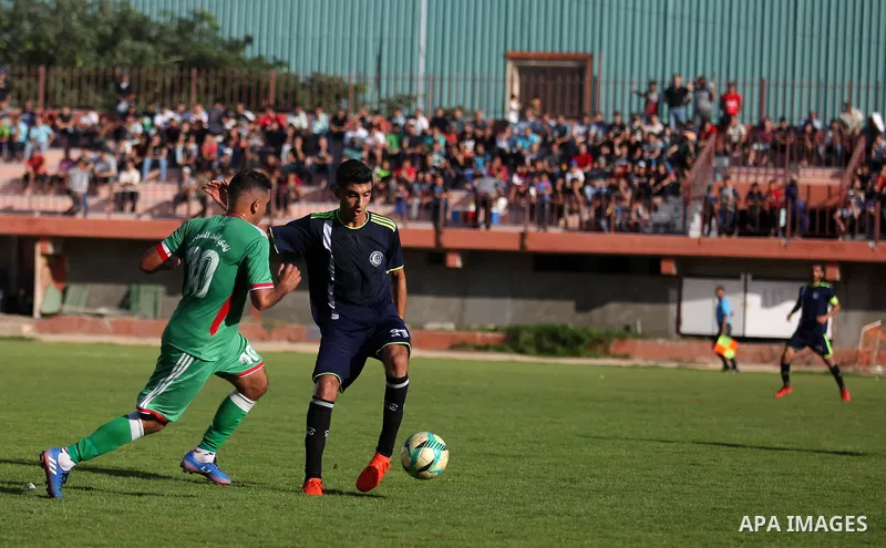 Palestinian football players of Etihad All-Shijaiyah (Green) and Al-Hilal (Dark blue) compete during match premier League in Alyarmuk stadium, in Gaza City, on October 7, 2019. Photo by Mahmoud Ajjour