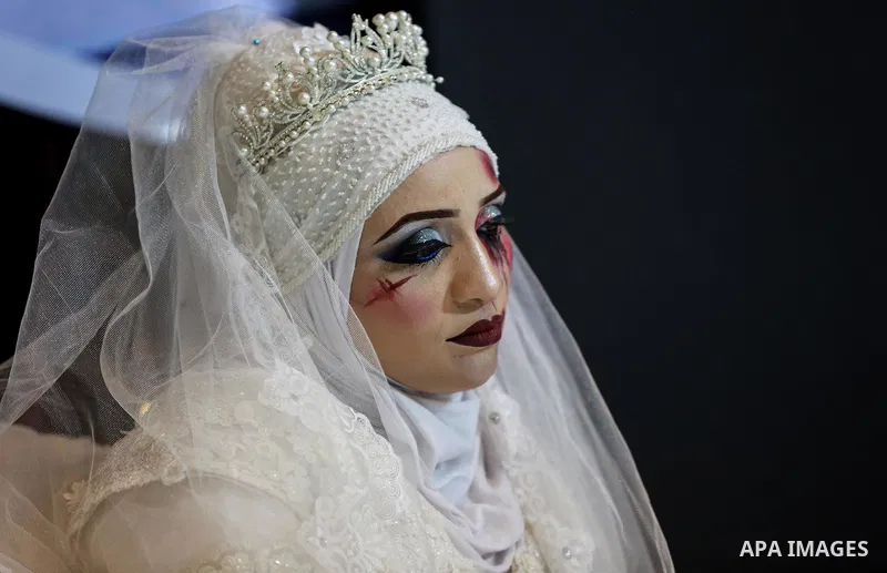 A Palestinian woman wears wedding dress as she takes part an event against violence towards women in Gaza City on October 10, 2019. Photo by Ashraf Amra